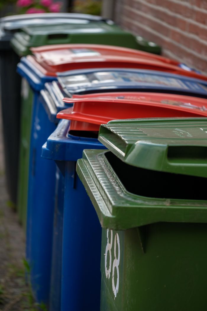 Services Row of colorful waste bins against a brick wall in Almere, Netherlands.